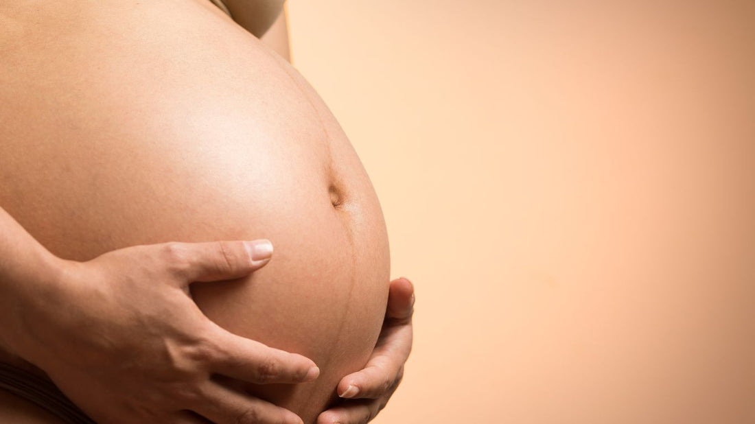 Une femme enceinte souriante et heureuse, coiffée avec soin après avoir subi un lissage brésilien. Ses cheveux sont lisses et brillants, et sa coiffure tient bien en place