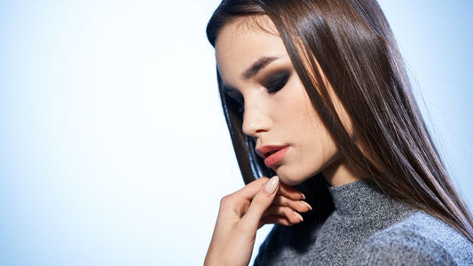 Une jeune femme souriante et fière, avec des cheveux lisses et brillants grâce à un lissage brésilien réussi. La photo montre les résultats durables de cette technique de lissage des cheveux.